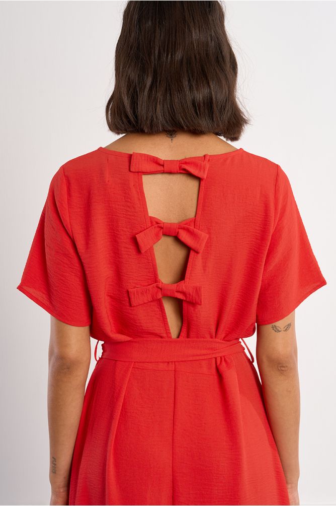Vestido largo, con lazada y aberturas en la espalda.