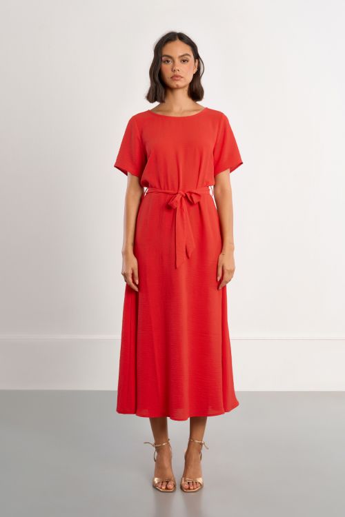 Vestido largo, con lazada y aberturas en la espalda.