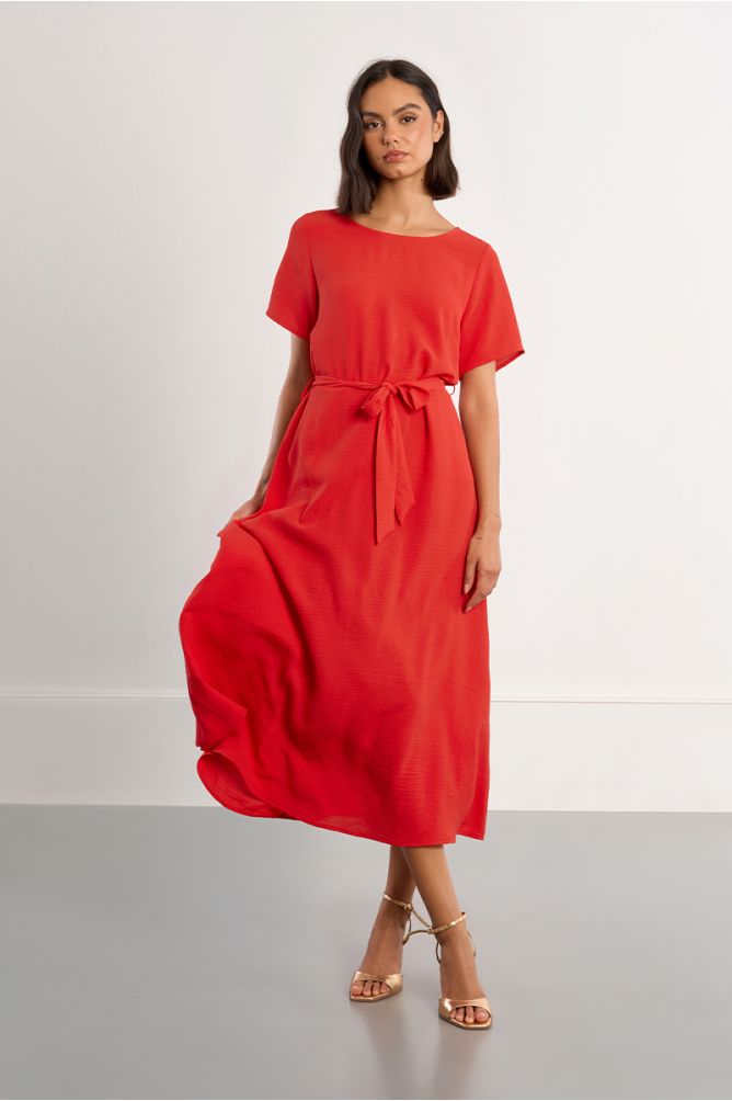 Vestido largo, con lazada y aberturas en la espalda.