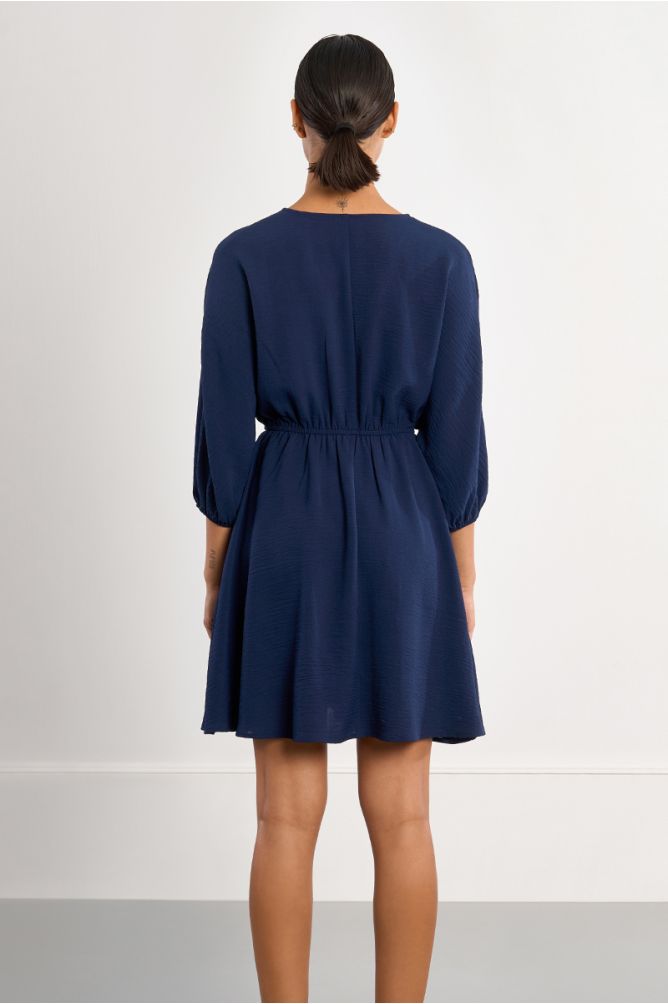 Vestido corto, de manga larga, detalle pliegues.