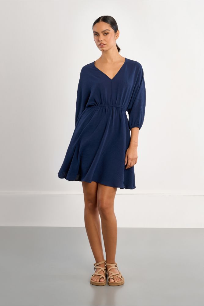 Vestido corto, de manga larga, detalle pliegues.