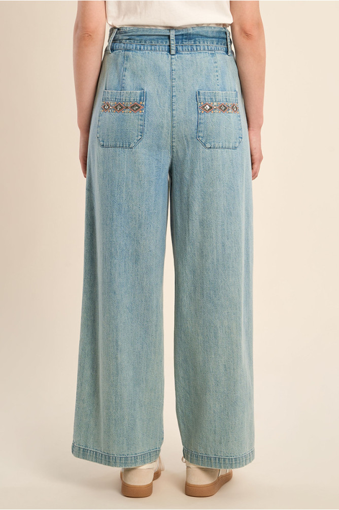 Pantalón de mujer largo, vaquero, con lazada y abalorios.
