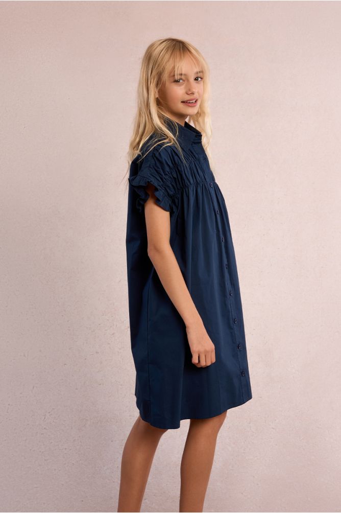 Vestido de niña corto, camisero, con pliegues.