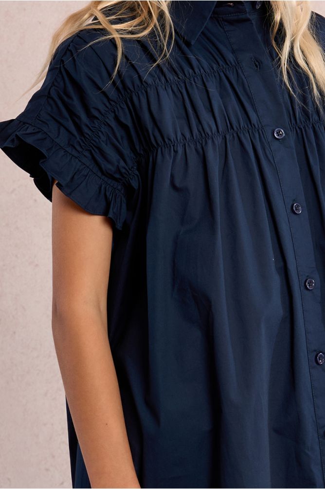 Vestido de niña corto, camisero, con pliegues.