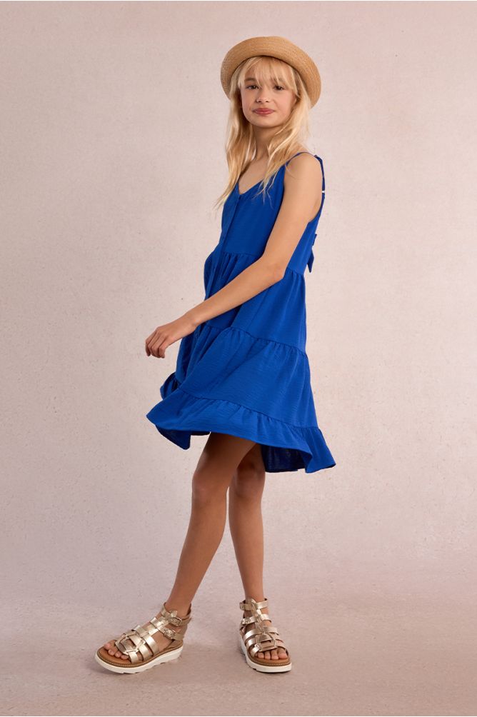Vestido de niña de tirantes, con volantes y lazada.